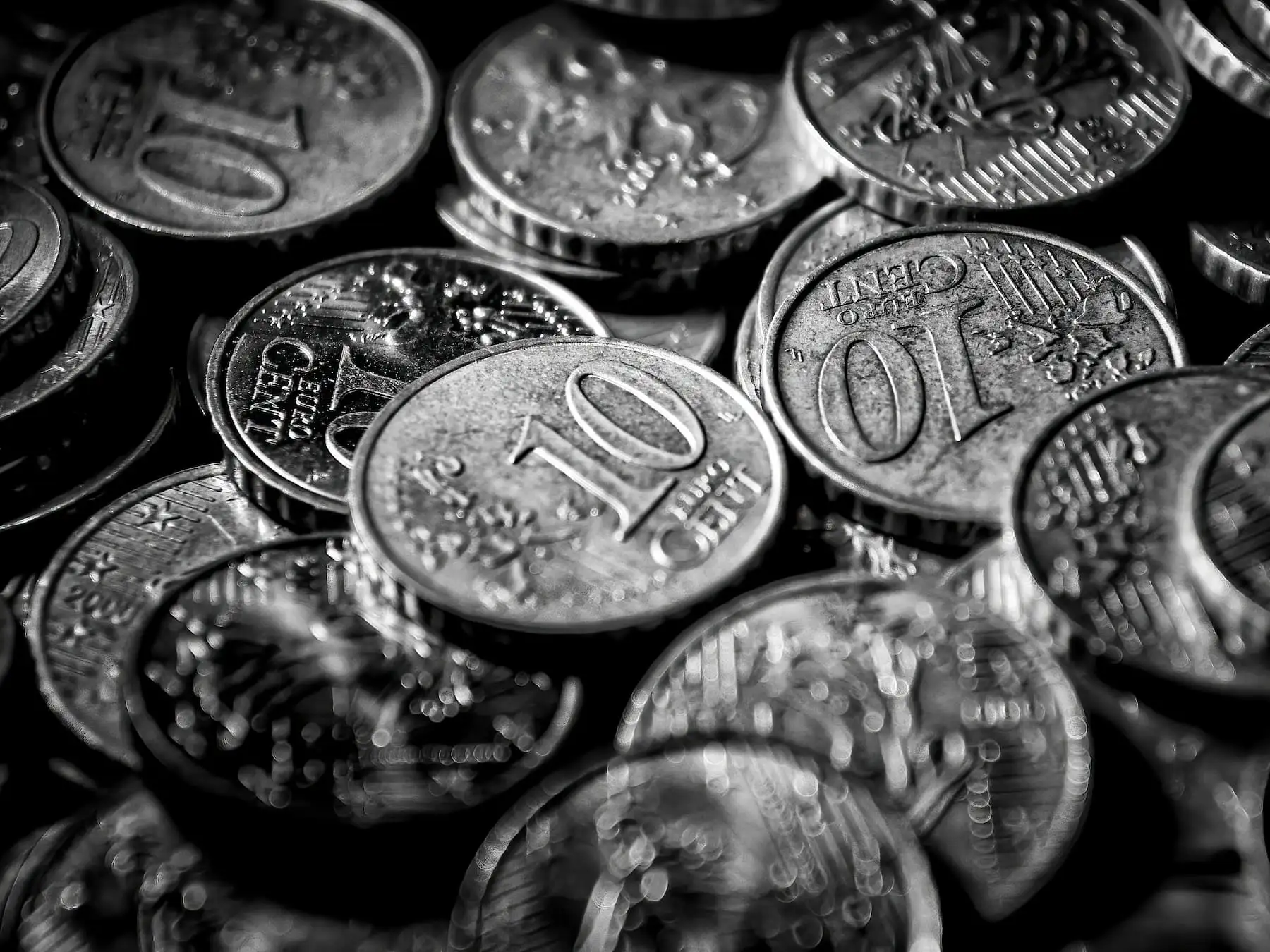 Mehrere Münzen in Schwarz-Weiß, Sinnbild für das richtige Budget bei der Hühnerhaltung.